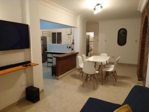 a living room with a table and chairs and a television at Pequeño Paraíso un lugar ventilado y acogedor in El Placer