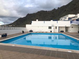 una piscina frente a un edificio con montaña en Calle del Sol Bajamar Apartment, en La Laguna