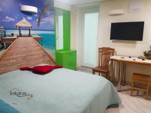 a bedroom with a bed and a pier with a television at INKARAS Aparthotel in Palanga