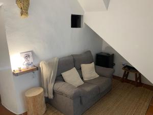 a living room with a gray couch and a staircase at La Cueva de Alabama in Mijas