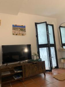 a living room with a flat screen tv and a window at La Cueva de Alabama in Mijas