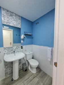 a bathroom with a white toilet and a sink at Huelva Art in Huelva