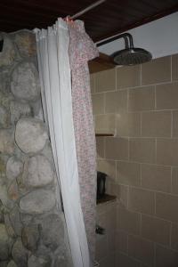 a shower curtain in a bathroom next to a stone wall at Los Aramos in Valle de Anton
