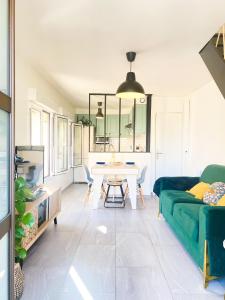 uma sala de estar com uma mesa e um sofá verde em AeroHome - Appart Confort - Aeroport d Orly à proximité - Parking em Athis-Mons