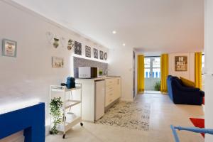 sala de estar con cocina y escalera en Oporto Blue Trindade - Magical Citycenter Apartment, en Oporto