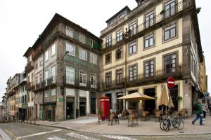un grupo de edificios con mesas y una cabina telefónica roja en Oporto Blue Trindade - Magical Citycenter Apartment, en Oporto