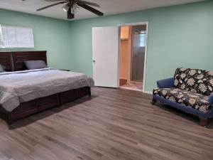 um quarto com uma cama, um sofá e uma cadeira em Comfortable, Affordable Oasis in Altamonte Springs for a Couple or Family em Orlando