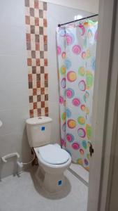 a bathroom with a toilet and a shower curtain at Hospedaje El Cerrito 2 in El Cerrito