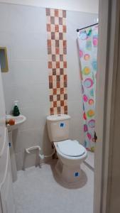 a bathroom with a toilet and a shower curtain at Hospedaje El Cerrito 2 in El Cerrito
