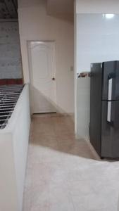 a kitchen with a white door and a refrigerator at Hospedaje El Cerrito 2 in El Cerrito