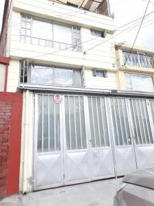 una puerta de garaje blanca frente a una casa en V&B Apartamento, en Bogotá