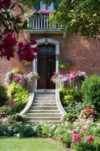ein Backsteinhaus mit einer Treppe, die zu einer Tür mit Blumen führt in der Unterkunft B&B Villa Ines in Lido di Venezia