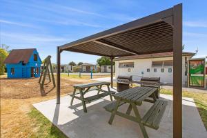 a picnic table and a play park with a playground at Hamilton City Holiday Park in Hamilton