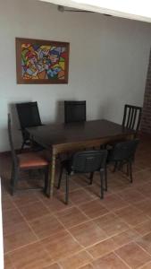 a dining room table with chairs and a painting on the wall at N6-CASA CÉNTRICA 2 DORMITORIOS Con AIRE ACONDICIONADO in Artigas