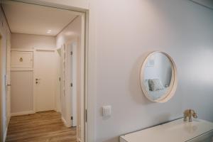 a white bathroom with a mirror on the wall at Alojamento Amélie - Apartamento in Braga