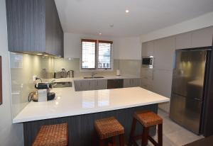a kitchen with a white counter and a refrigerator at Jagungal in Thredbo