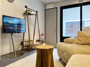 a living room with a couch and a flat screen tv at SAKON UKON in Kanazawa