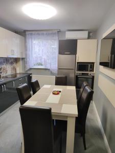 a kitchen with a table and chairs in a room at Apartament Adagio Felix in Baile Felix