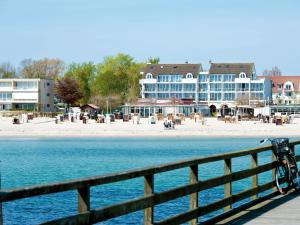 ein Fahrrad auf einem Zaun neben einem Strand geparkt in der Unterkunft Ostsee-Hotel in Großenbrode