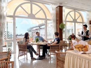 un grupo de personas sentadas en una mesa en un restaurante en Ostsee-Hotel, en Großenbrode