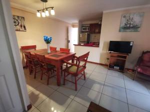 a dining room with a wooden table and chairs at Departamento Vistamar 2 Puertas Pacifico in Arica