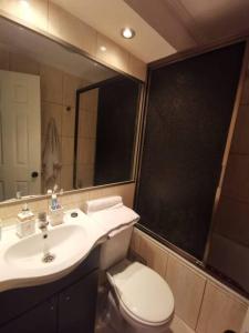 a bathroom with a sink and a toilet and a mirror at Departamento Vistamar 2 Puertas Pacifico in Arica