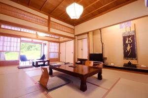 sala de estar con mesa y TV. en 高野山 宿坊 不動院 -Koyasan Shukubo Fudoin-, en Koyasan