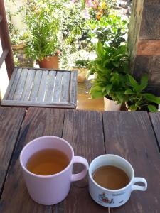 dwie filiżanki kawy siedzące na drewnianym stole w obiekcie 288 Villa w mieście Da Lat