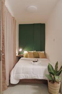 sypialnia z dużym łóżkiem z zielonym zagłówkiem w obiekcie AJ Coffee & Bed w mieście Coron