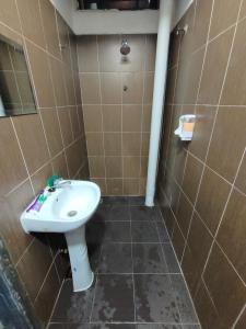 La salle de bains est pourvue de toilettes et d'un lavabo. dans l'établissement Alish Homestay Gua Musang with Free WiFi, Netflix, à Gua Musang