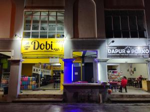 a building with a yellow and blue sign on it at Alish Homestay Gua Musang with Free WiFi, Netflix in Gua Musang
