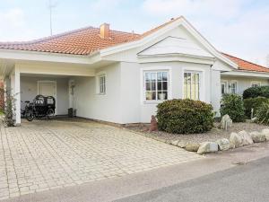 a white house with a motorcycle parked in the driveway at Holiday home SÖLVESBORG XIII in Sölvesborg