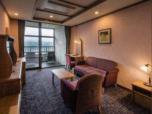 une chambre d'hôtel avec un canapé et un salon dans l'établissement La Vista Kusatsu Hills, à Kusatsu