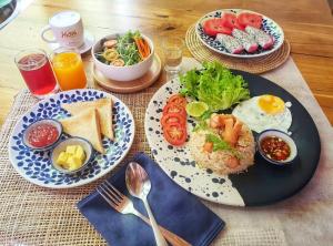 a table with plates of breakfast foods and drinks at Norn Talay Surin Beach Phuket in Surin Beach