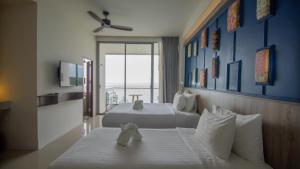 a hotel room with two beds with teddy bears on them at Norn Talay Surin Beach Phuket in Surin Beach