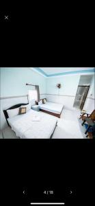 a large room with two beds and a desk at An Phát Motel in Quy Nhon