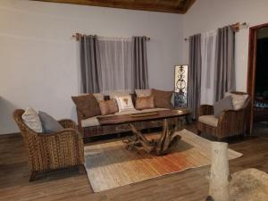 uma sala de estar com um sofá, uma mesa e cadeiras em Ecoscape Jamaica - Lavish 1-br cottage by the river em Saint Annʼs Bay