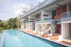 an image of a swimming pool in front of a building at Norn Talay Surin Beach Phuket in Surin Beach