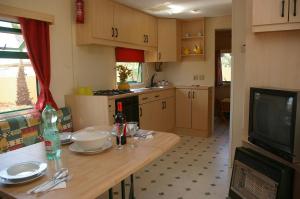 a small kitchen with a table and a television at Akramar Village in San Leone
