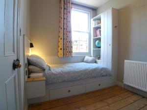 a small bedroom with a bed with a window at Kittiwake Cottage in Scarborough