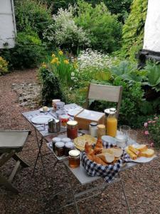 una mesa de picnic con pan y comida. en Le Collet Vert en Wamin