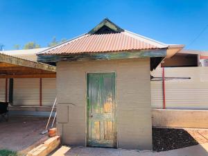 a small house with a green door in front at Entire 4 Bedroom pets friendly home in Alice Springs CBD with 2 kitchens 2 bathrooms Toilets and plenty of free secured parking in Alice Springs
