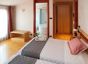 1 Schlafzimmer mit einem großen Bett und einem Badezimmer in der Unterkunft Hotel Contà Taste The Experience in Pieve di Soligo