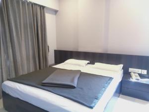 Postel nebo postele na pokoji v ubytování Sai Heera Residency Shirdi