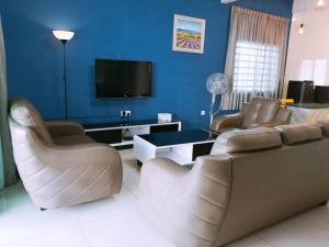 sala de estar con sofá, sillas y TV en W36 WarmStay atGoldenHills NightMarket 4R Wifi BBQ, en Brinchang