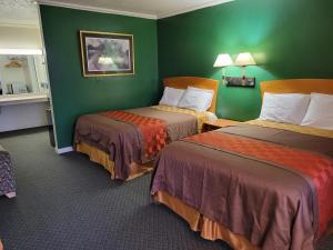 - une chambre d'hôtel avec 2 lits aux murs verts dans l'établissement Emerald Inn & Lounge, à Blythe