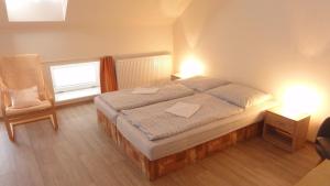 a bedroom with a bed and a chair and a window at Penzion U Hradeb in Znojmo