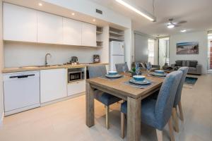 cocina y comedor con mesa de madera y sillas en Bright Point 1308 at Magnetic, en Nelly Bay