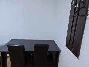 Hotel Safta Residence في كرايوفا: طاولة غرفة طعام سوداء مع كرسيين سوداوين