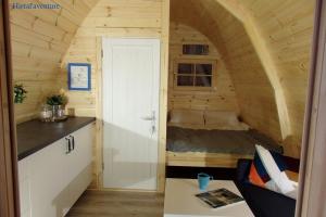 małą kuchnię z łóżkiem w małym domku w obiekcie Camping du lac w mieście Saint-Julien-du-Verdon